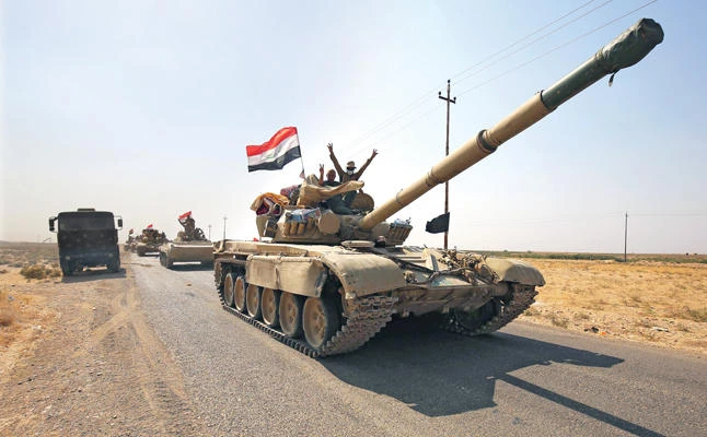 Iraqi forces drive toward Kurdish peshmerga positions on Sunday on the southern outskirts of Kirkuk. (AFP)