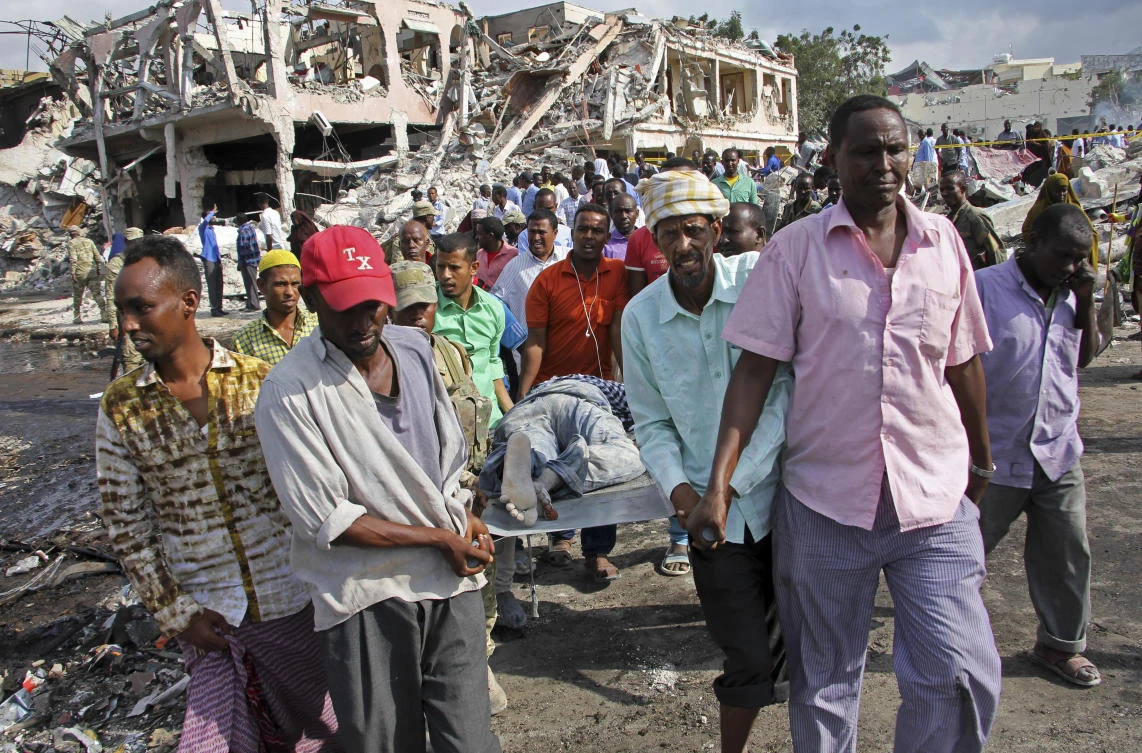 Somalis remove the body of a man killed in Saturday’s blast, in Mogadishu, Somalia Sunday, Oct. 15, 2017. (AP/Farah Abdi Warsameh)