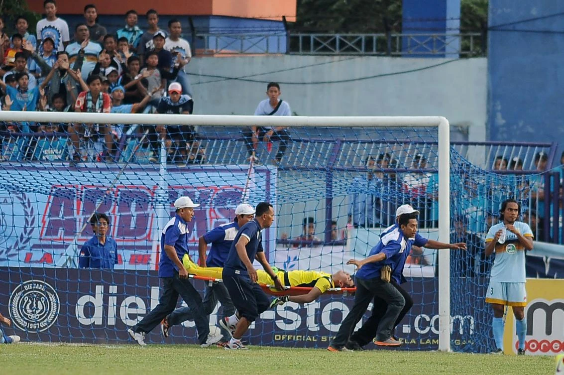 This picture taken on Oct. 15, 2017 shows goalkeeper Choirul Huda of hometown club Persela in East Java being rushed away on a stretcher and taken to hospital after colliding with Brazilian midfielder Ramon Rodrigues during a match at Surajaya Lamongan stadium in Surabaya. (AFP)