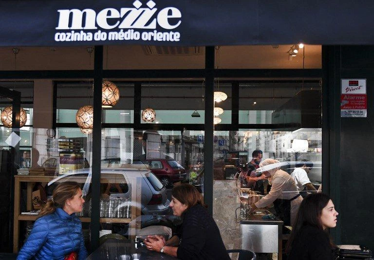 Clients sit outside the Syrian refugees-owned restaurant ‘Mezze’ in Lisbon on September 19, 2017. (File photo by AFP)