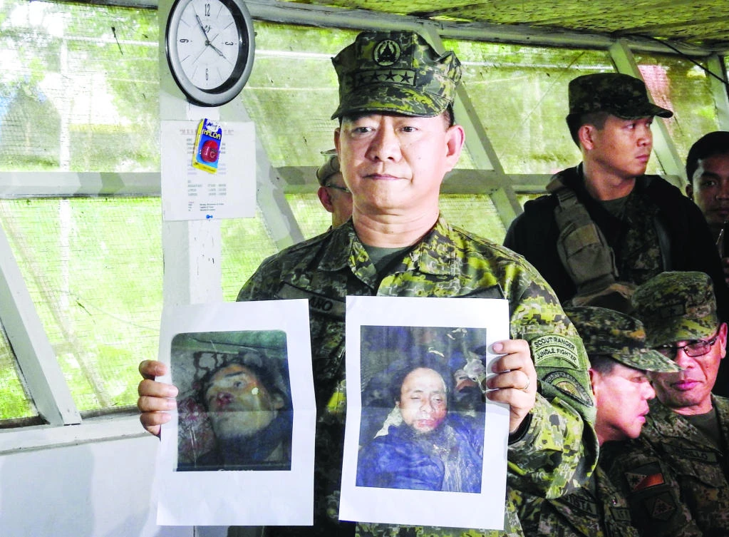 Philippine military chief General Eduardo Año shows images of Islamic militant leaders Isnilon Hapilon, right, and Omarkhayam Maute, left, during a press conference at a military camp in Marawi on the southern island of Mindanao on Monday. (AFP)