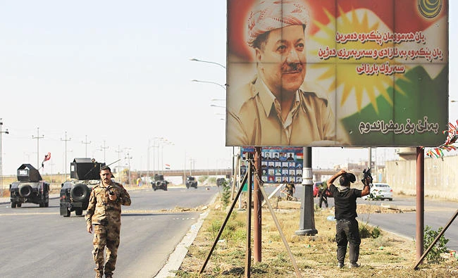 A banner bearing a portrait of Kurdish regional president Massoud Barzani is seen as Iraqi forces advance towards Kirkuk on Monday. (AFP)