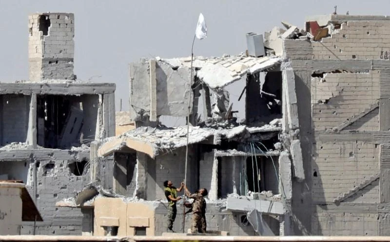 Fighters of Syrian Democratic Forces raise a white flag near the National Hospital complex where the Islamic State militants are holed up, at the frontline in Raqqa, Syria October 16, 2017. (REUTERS)