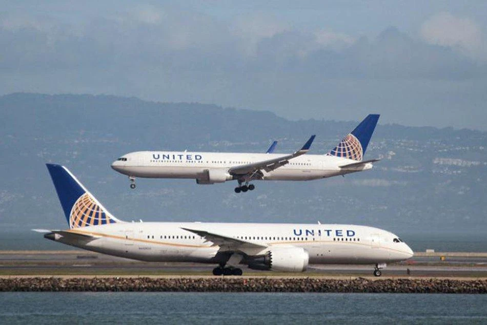 A United Airlines jet taxis as another lands at San Francisco International Airport. (Reuters)