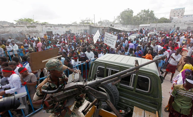 A Somali soldier sits with a machine gun on top of a truck as protesters march with placards reading "Out Al Shabab" near the scene of Saturday's massive truck bomb attack in Mogadishu, Somalia, on Wednesday, Oct. 18, 2017. (AP)