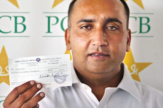 Meher Mohammad Khalil, the bus driver who drove the Sri Lankan cricket team to safety during an attack by gunmen on March 3, poses with his award cheque for 500,000 Pakistani rupees (USD 6,222) following a ceremony in Lahore on March 18, 2009. (File photo by AFP)