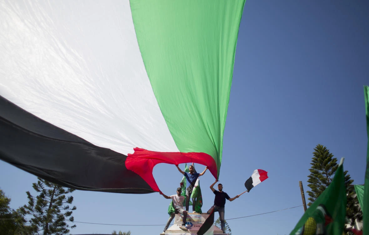 Palestinians in Gaza City wave national and Egyptian flags to celebrate the reconciliation agreement between Hamas and Fatah in Egypt. (AP)