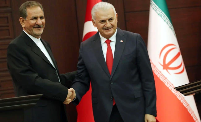 Turkish Prime Minister Binali Yildirim (R) and Iran's First Vice President Eshaq Jahangiri (L) shake hands as they hold a joint press conference at Cankaya Palace in Ankara on October 19, 2017. (AFP)