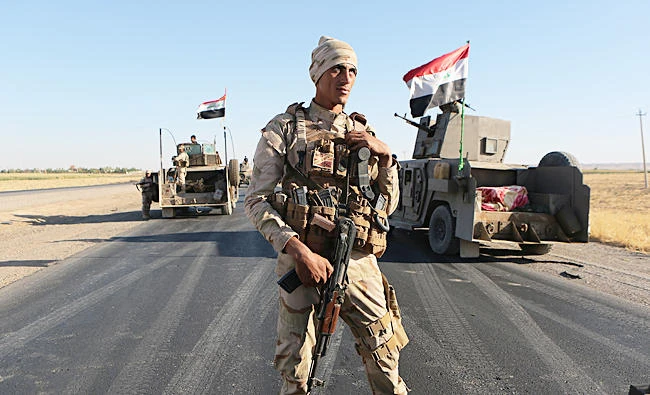 Federal Iraqi security forces gather outside the Kurdish hold City of Alton Kupri, outskirts of Irbil, Iraq. (AP)