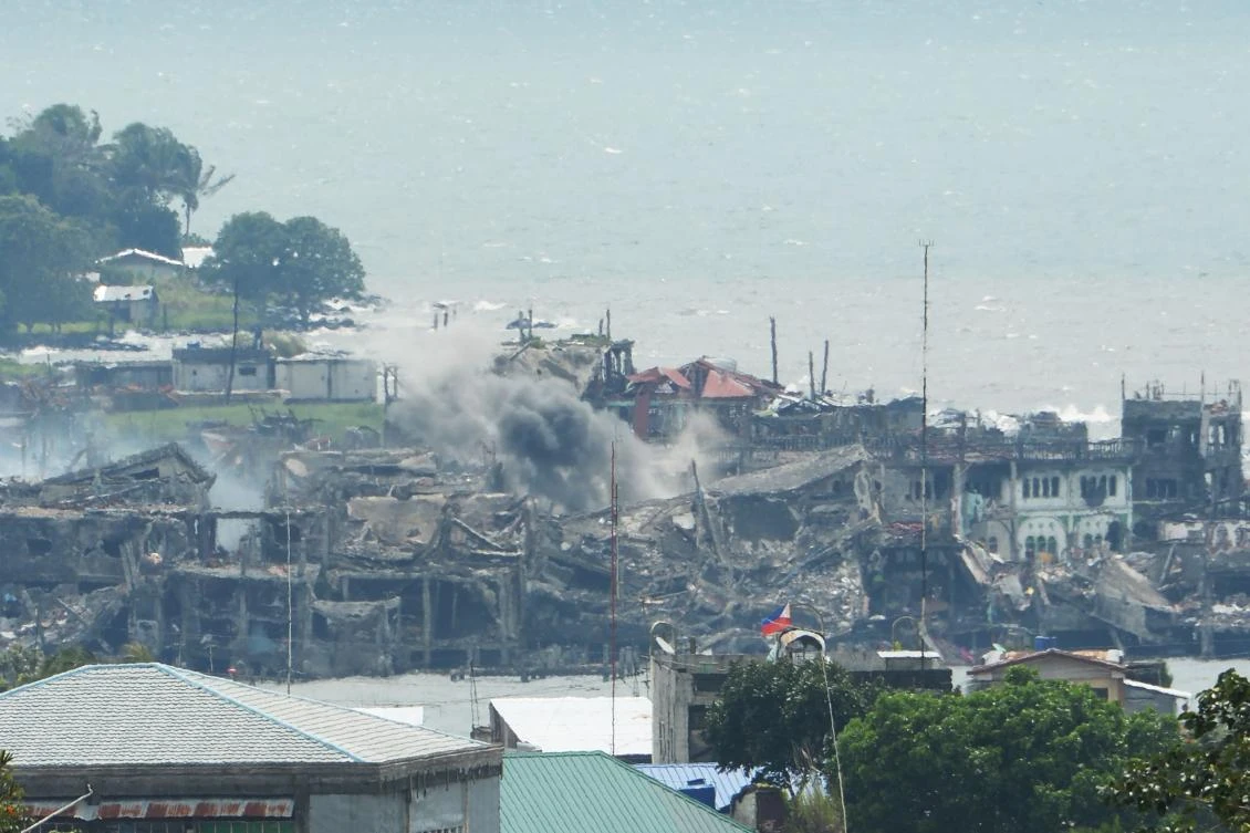 Black smoke billows from destroyed buildings after an artillery fire from government troops at the remaining militant postion near the lake in Marawi. (AFP)