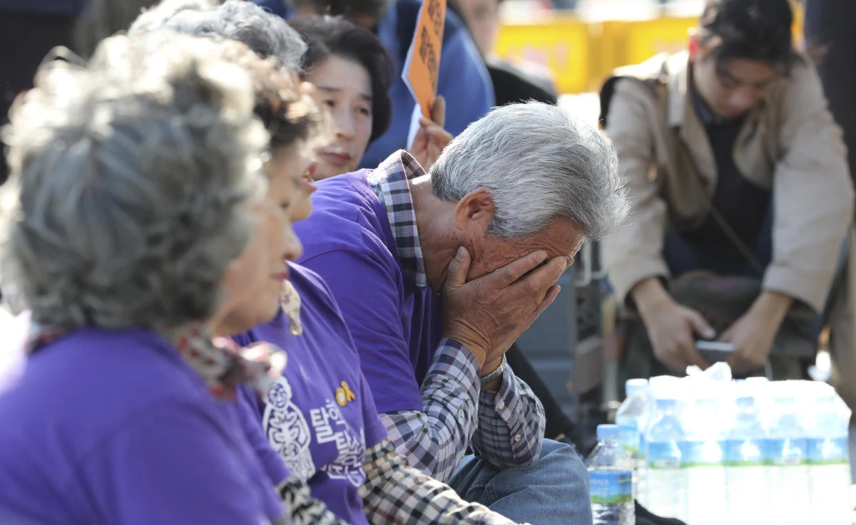 A South Korean man opposing to the construction of nuclear reactors, covers his face with hands after a state commission announced about a public survey result for two stalled nuclear reactors. (AP)