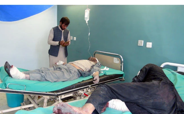 In this October 17, 2017, photo, Afghan men receive treatment at a hospital after a suicide car bomber and gunmen attacked a provincial Afghan police headquarters in Gardez. On Friday, at least 63 people were killed in two suicide bomb attacks targetting mosques in Kabul and western Ghor province. (REUTERS)