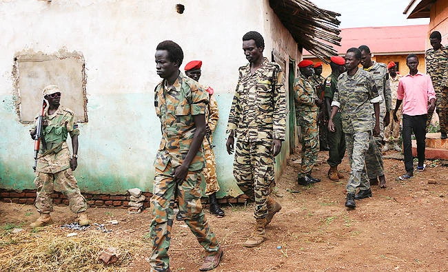 In this May 30, 2017 photo, South Sudanese soldiers accused of a horrific attack on foreign aid workers including rape, torture, killing and looting on the Terrain hotel compound, are assisted to a prison van after attending their trial in the capital Juba, South Sudan. (AP)