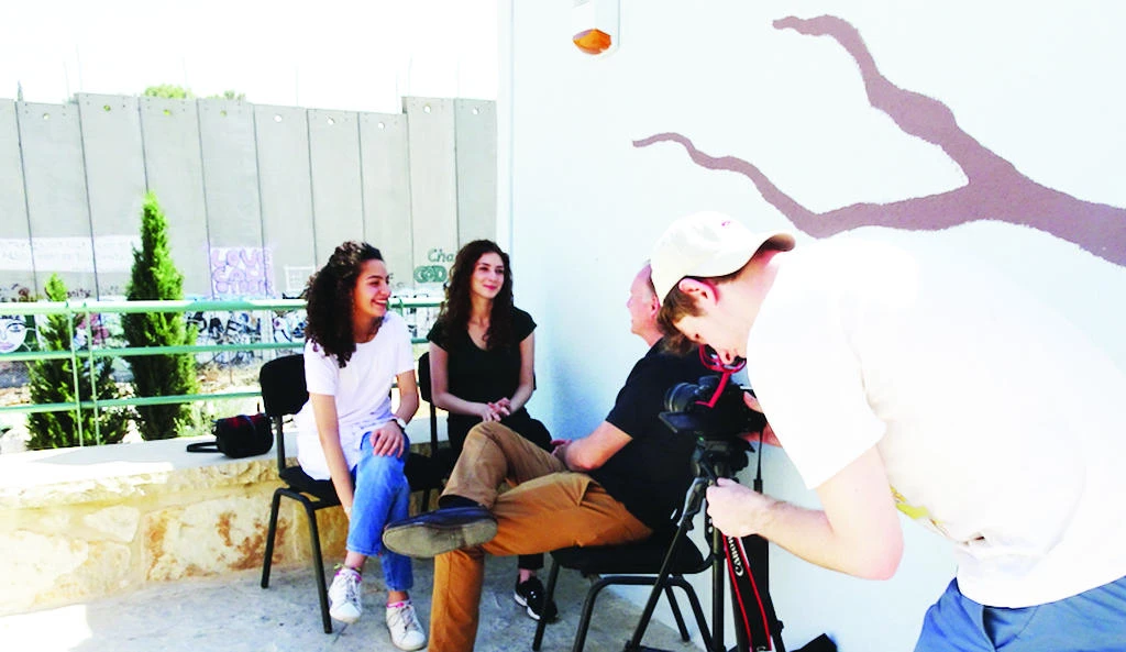 Palestinian students Leen and Georgina talking to documentary maker Martin Buckley on the roof of Wi’am Palestinian conflict transformation center in Bethlehem about the legacy of the Balfour Declaration on their day-to-day lives. (AN photo)