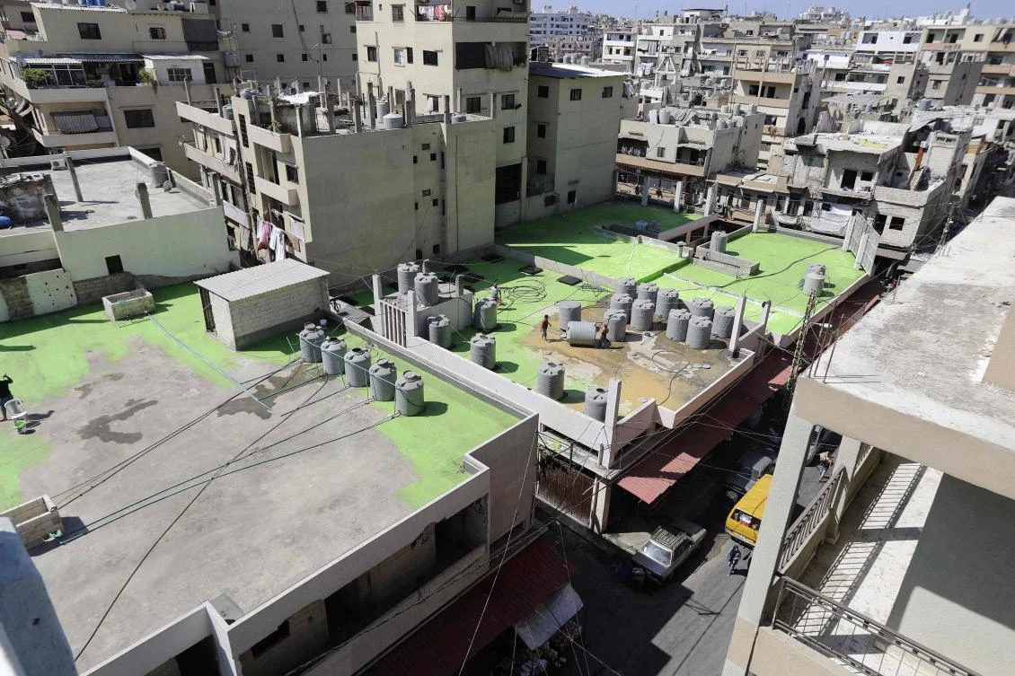 Lebanese painters take part in a project, that aims to draw the word Peace in Arabic across 85 rooftops, in Tripoli’s Syria street which separetes the Sunni neighborhood of Bab Al-Tabbaneh from the Alawite neighborhood of Jabal Mohsen, in Tripoli on September 28, 2017. (AFP)