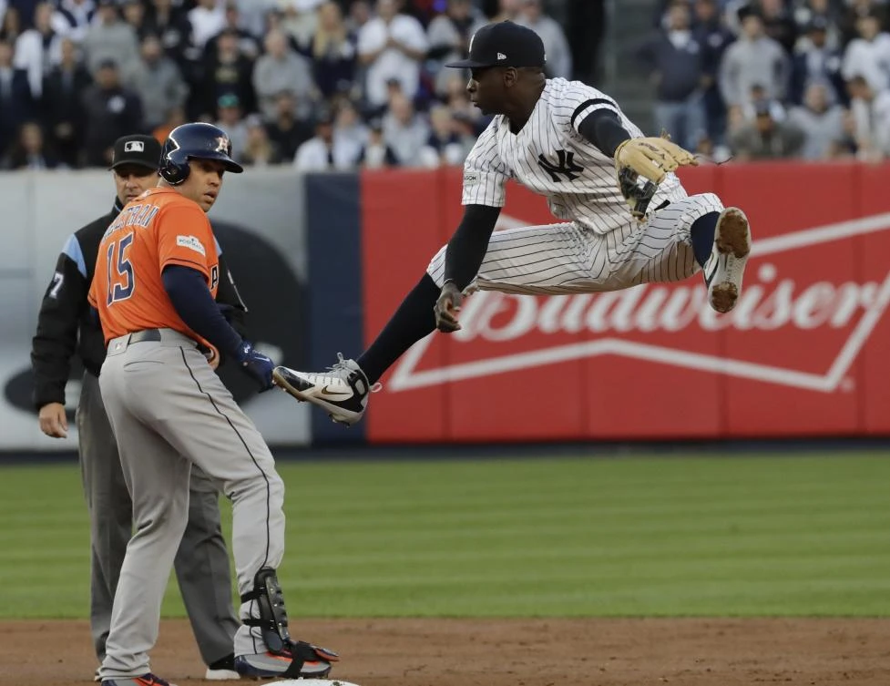 New York Yankees’ Didi Gregorius leaps to catch a ball thrown in from the outfield as Houston Astros’ Carlos Beltran is safe at second with a double during the American League Championship Series. (AP)