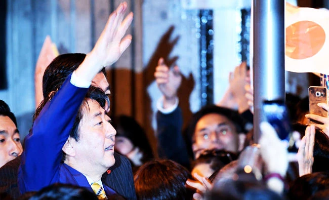 Japan's Prime Minister and ruling Liberal Democratic Party leader Shinzo Abe (L) waves to supporters during his last stumping tour for the October 22 general election in Tokyo on Saturday. (AFP)