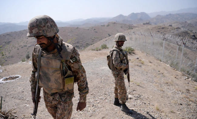 Pakistani soldiers patrol next to a newly fenced border along Afghan border at Kitton Orchard Post in Pakistan's North Waziristan tribal agency on October 18, 2017. Pakistani paramilitary troops have killed eight militants from a group which tried to assassinate an opposition politician in Karachi, officials said. (AFP)
