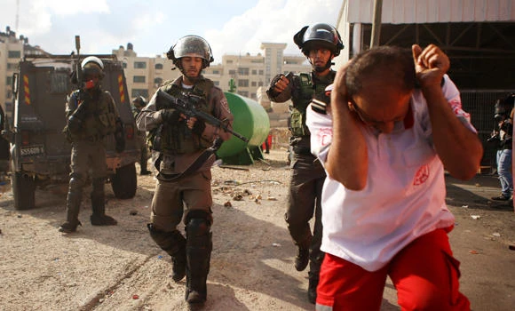 In this file photo, an Israeli policeman uses pepper spray against a Palestinian medic during clashes outside Ramallah, West Bank. Israeli police have arrested 15 suspected Jewish extremists over campaign to stop Jew-Arab dating. (AP)