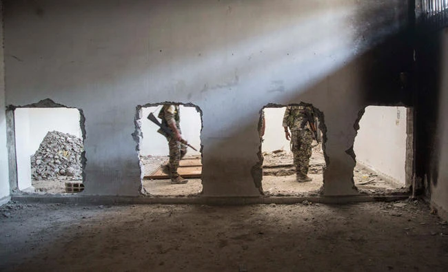 Members of the U.S. backed Syrian Democratic Forces (SDF) walk inside the stadium that was the site of Daesh fighters' last stand in the city of Raqqa, Syria. (AP)