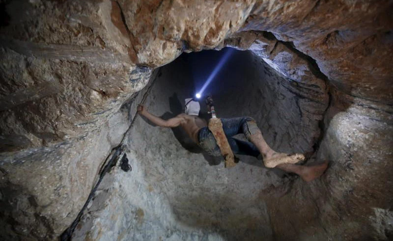 A Palestinian worker is lowered on a rope into a smuggling tunnel, that was flooded by Egyptian security forces, beneath the border between Egypt and southern Gaza Strip on November 2, 2015. (File photo by Reuters)