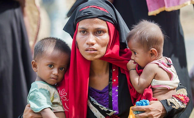 Rohingya Muslim woman, Rukaya Begum, who crossed over from Myanmar into Bangladesh, holds her son Mahbubur Rehman, left and her daughter Rehana Bibi, after the government moved them to newly allocated refugee camp areas, near Kutupalong, Bangladesh, on Sunday. (AP)