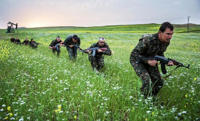 This file photo taken on April 30, 2015 shows Foreign fighters who joined the Kurdish People's Protection Units (YPG) to fight in their ranks against jihadists and Islamist rebels in northeastern Syria taking part in a training session on April 30, 2015 in the south-west Syrian region of Ras al-Ain, close to the Turkish border. (AFP)