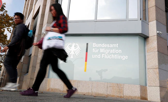 People walk in front of an office building of the Federal Office for Migration and Refugees (BAMF) in Berlin, Germany, on October 15, 2017. (Reuters)