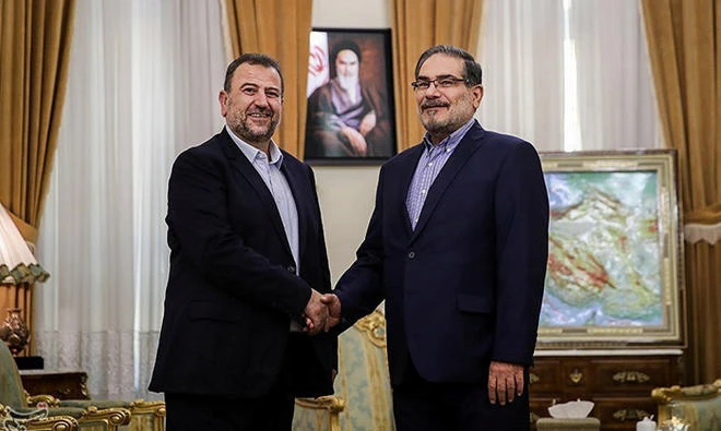 Saleh Al-Arouri (L), Hamas deputy chief, shakes hands with Ali Shamkhani, secretary of Iran's National Security Council, during their meeting in Tehran, Iran, on October 21, 2017. (Reuters)