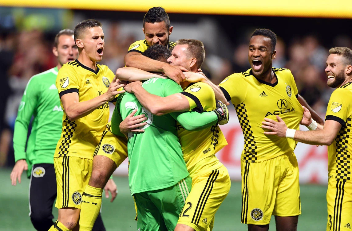 Columbus Crew forward Adam Jahn (12) reacts with goalkeeper Zack Steffen (23) and fellow Crew teammates after scoring the winning shootout goal against the Atlanta United during the Eastern Conference knockout round soccer game at Mercedes-Benz Stadium. The Columbus Crew won in a 3-1 shootout. (John David Mercer-USA TODAY Sports)
