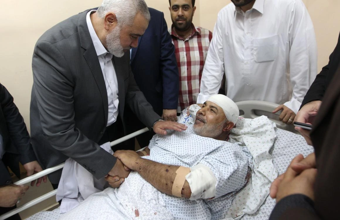 A handout picture released on October 27, 2017 by the office of Gaza’s senior Hamas leader Ismail Haniya shows him (R) visiting Tawfiq Abu Naim (C), director general of the internal security forces, at a hospital in Gaza City. (AFP/Ismail Haniya’s office/Handout)