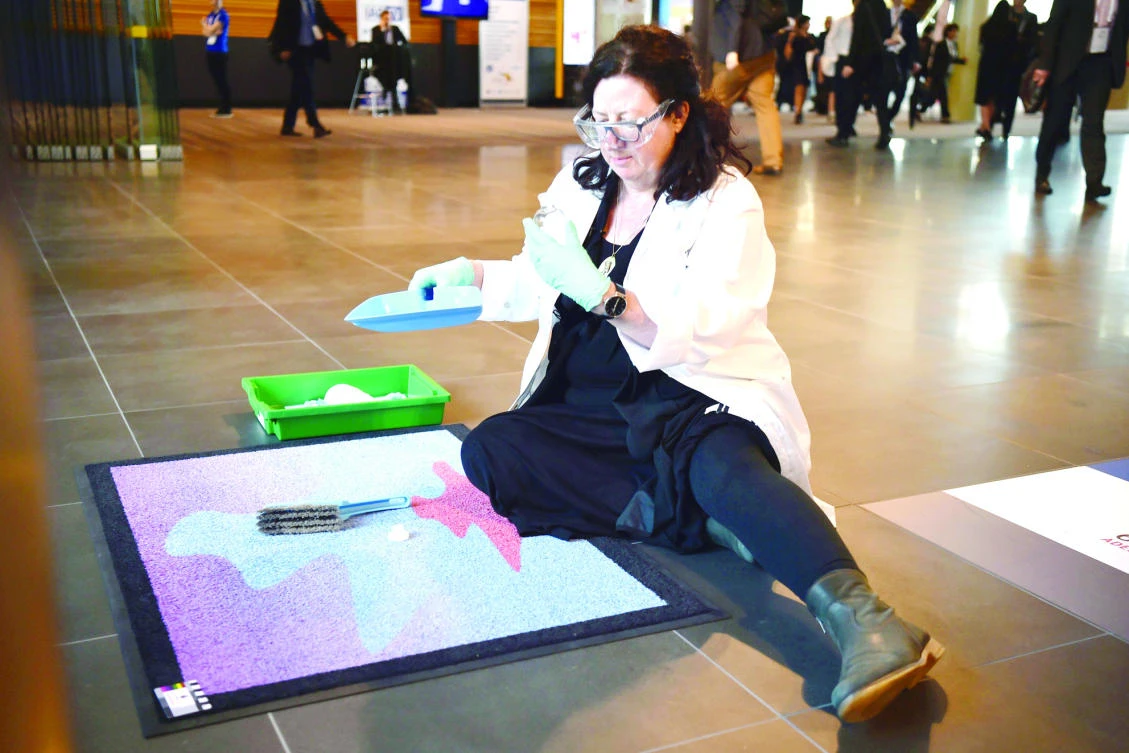 Australian space archaeologist Alice Gorman sweeps the ‘Cosmic Welcome Mat’ for space particles at the entrance to the 68th International Astronautical Congress on Sept. 28. in Adelaide. (AFP)