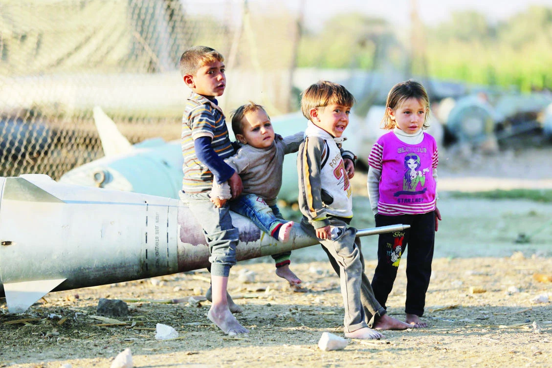 Syrian children play as they sit on the tip of an abandoned missile at the Ash’ari camp for the displaced in the opposition-held eastern Ghouta outside Damascus. (AFP)