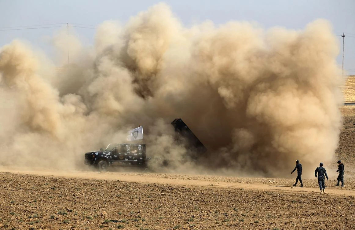 Above, dust clouds swirling around an Iraqi security forces’ rocket launcher after firing against Kurdish positions in the area of Faysh Khabur. Canadian special forces have temporarily suspended military assistance to Iraqi troops. (AFP)
