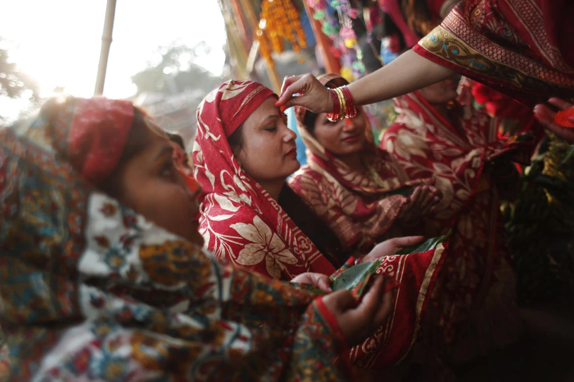 A Nepalese woman puts vermillion powder on the forehead of another while offering prayers to the setting sun on the banks of the Bagmati River during the Hindu Chhath Puja festival in Katmandu. (AP)