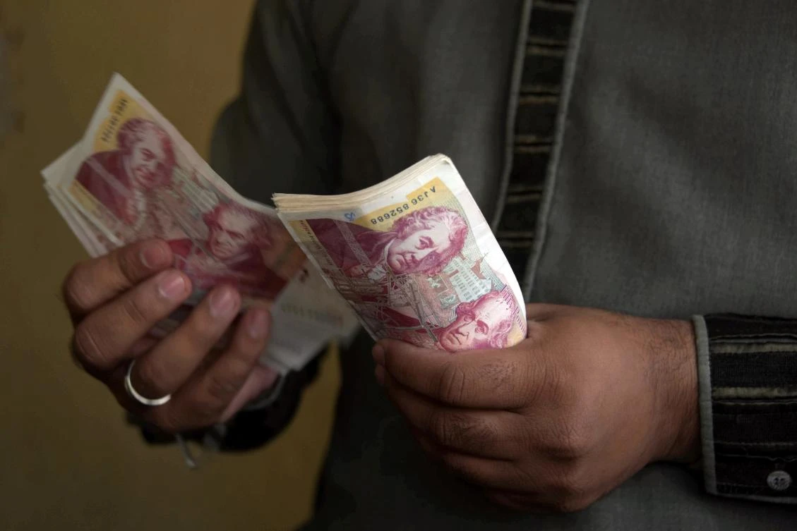 This photograph taken on October 19, 2017 shows a Pakistani Kashmiri foreign currency dealer counting British pound notes at a remittance shop in the Pakistani Kashmir city of Mirpur, which is known as "Little England." (AFP)