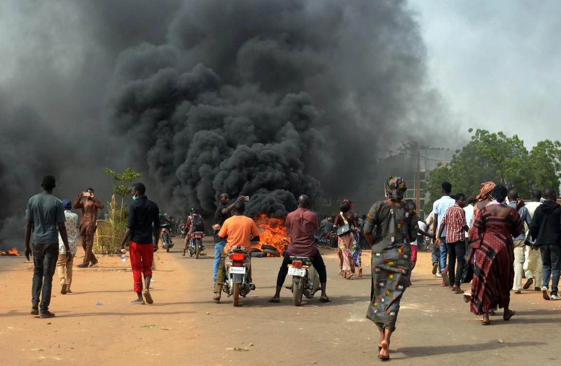 People walk near burning tyres during clashes between protesters and police at a demonstration against the 2018 Finance law on October 29, 2017, in Niamey. (AFP)