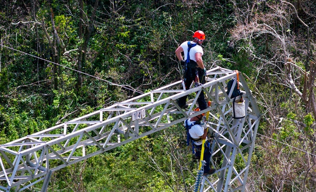 In this Oct. 15, 2017 photo, Whitefish Energy Holdings workers restore power lines damaged by Hurricane Maria in Barceloneta, Puerto Rico. (AP)