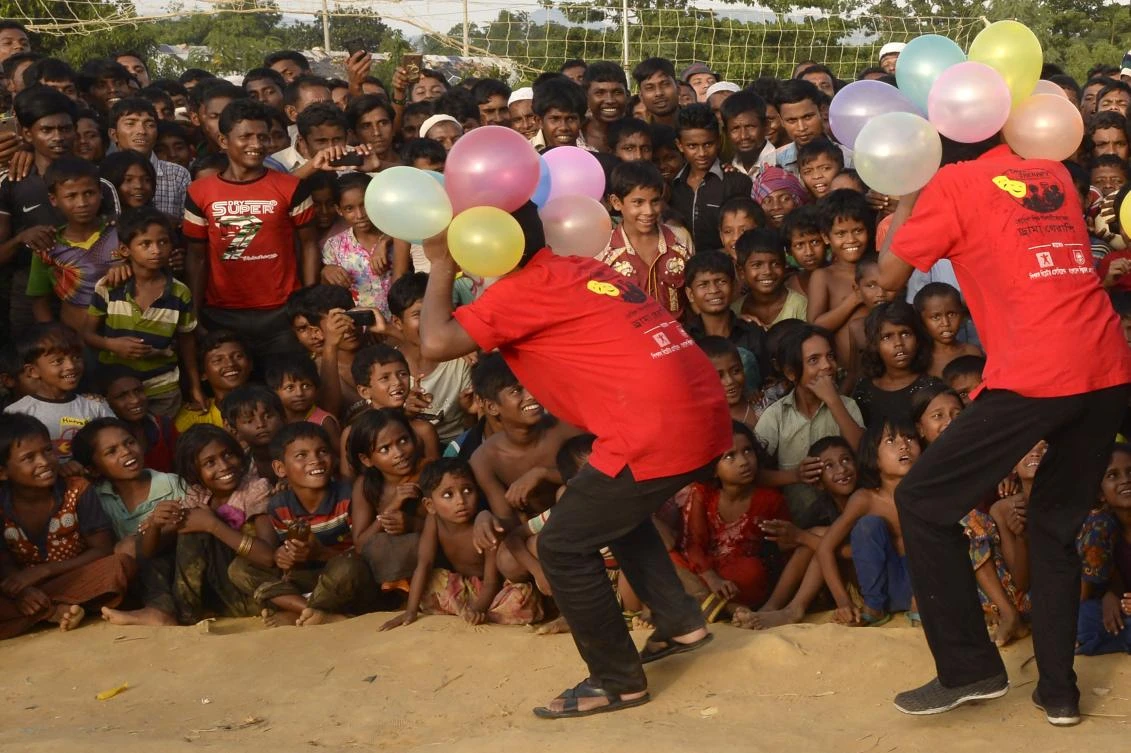 This photograph taken on October 28, 2017 shows Rohingya refugee children watching the Bangladeshi theater group “Drama Therapy” at Kutupalong refugee camp in Ukhia. (AFP)
