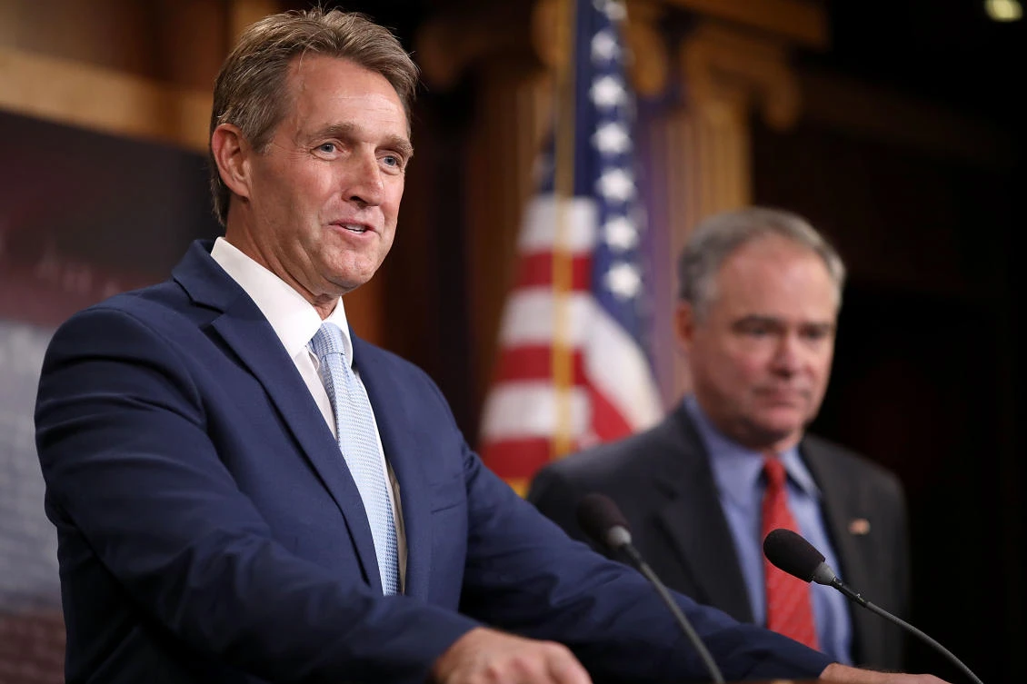 This file photo taken on May 24, 2017 shows Sen. Jeff Flake (R-AZ) (L) and Sen. Tim Kaine (D-VA) talking about their introduction of a new Authorization for the Use of Military Force (AUMF) against Daesh, Al-Qaeda and the Taliban during a news conference at the US Capitol in Washington, DC. (AFP)
