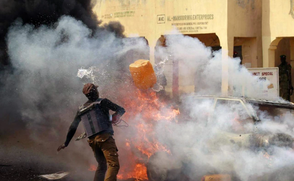 A man throws a container of water toward a burning car after a bomb explosion near Gombe stadium on February 2, 2015. (File photo by Reuters)
