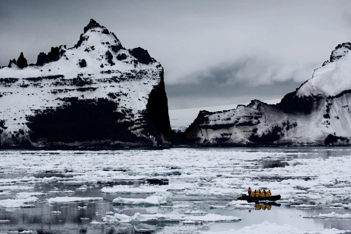 A supplied image shows a boat passing a rocky cliff in Antarctica, November 22, 2006. Picture taken December 22, 2006. John B. Weller-Pew Charitable Trust/Handout via REUTERS ATTENTION EDITORS — THIS IMAGE WAS PROVIDED BY A THIRD PARTY. NO RESALES. NO ARCHIVE.
