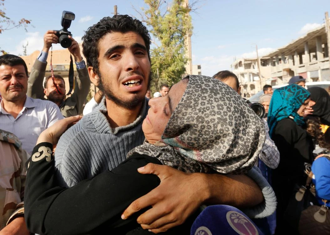 A Syrian man from the recently retaken desert town of Al-Qaryatain is greeted by relatives on Oct. 29, 2017, after the Syrian army reportedly freed him from Daesh detention. (AFP/Louai Beshara)