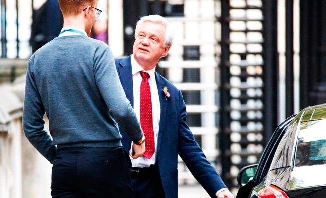 Britain's Secretary of State for Exiting the European Union (Brexit Minister) David Davis talks with a member of staff as he leaves his office in Downing Street in London on Tuesday. (AFP)