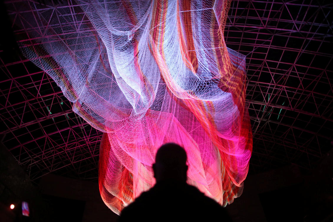 A man stands in front of an illuminated installation hanging from the ceiling during the International Festival of Lights in Mexico City, Mexico, November 16, 2017. REUTERS/Edgard Garrido NO RESALES. NO ARCHIVES.