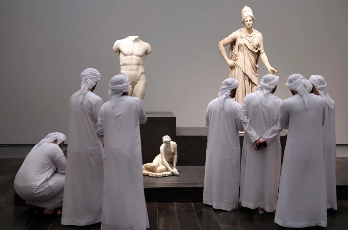 Emirati visitors look at exhibits during the opening of the Louvre Abu Dhabi Museum on November 11, 2017 on Saadiyat island in the Emirati capital. / AFP / KARIM SAHIB