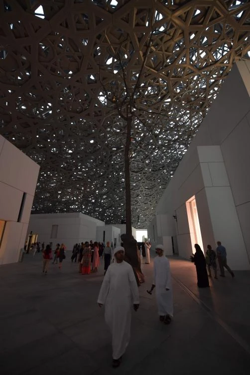 Visitors walk past a piece of art titled "Germination" by Italian artist Giuseppe Penone at the Louvre Abu Dhabi Museum on November 11, 2017 during its official opening to the public on Saadiyat island in the Emirati capital. More than a decade in the making, the Louvre Abu Dhabi opened its doors bringing the famed name to the Arab world for the first time. - RESTRICTED TO EDITORIAL USE - MANDATORY MENTION OF THE ARTIST UPON PUBLICATION - TO ILLUSTRATE THE EVENT AS SPECIFIED IN THE CAPTION / AFP / GIUSEPPE CACACE / RESTRICTED TO EDITORIAL USE - MANDATORY MENTION OF THE ARTIST UPON PUBLICATION - TO ILLUSTRATE THE EVENT AS SPECIFIED IN THE CAPTION