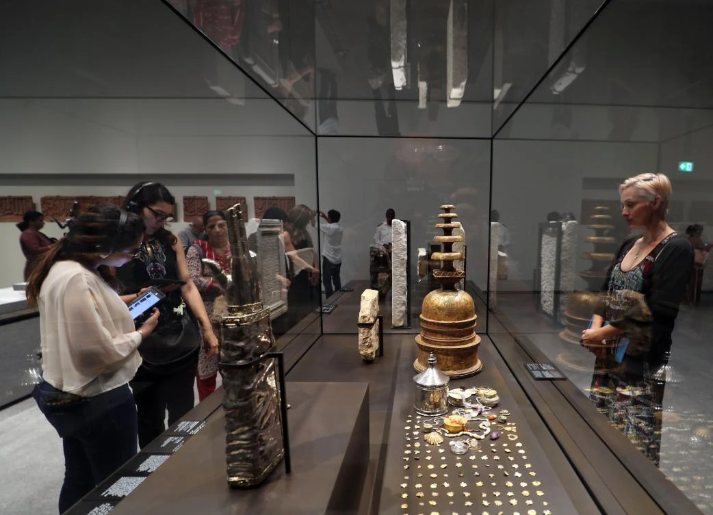 Visitors look at exhibits during the opening of the Louvre Abu Dhabi Museum on November 11, 2017 on Saadiyat island in the Emirati capital. / AFP / KARIM SAHIB
