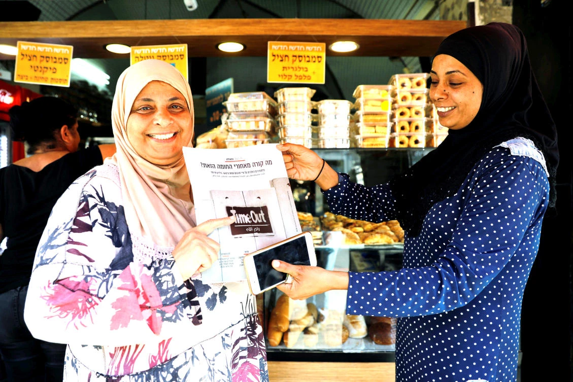 Arab-Israeli women hold a copy of ‘Time Out Ramallah.’ (Reuters)