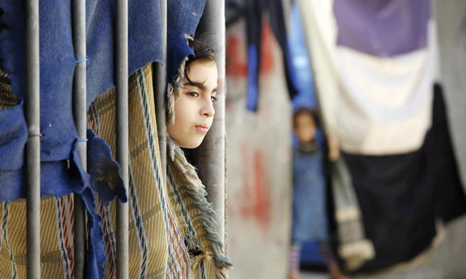 A Palestinian girl stands outside her house at Al-Shatee refugee camp in Gaza City, on Monday. (AFP)